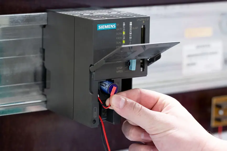 Schritt 3: Entnahme der alten Siemens SIMATIC S7-300 Pufferbatterie aus der Halterung unter Beachtung der Pluspol-Markierung; bei Modellen mit Kabel einfach den verpolungssicheren Stecker trennen.