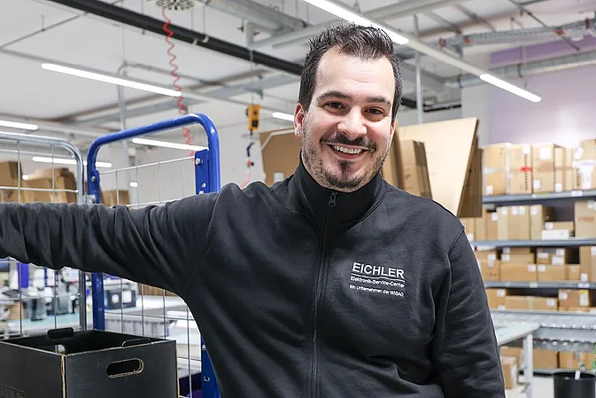 Smiling Eichler employee poses with new team apparel