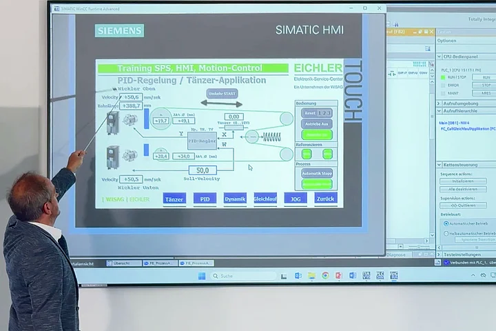 Schulungsleiter erklärt an der Leinwand die Funktion eines Siemens Simatic HMI Touch Panels