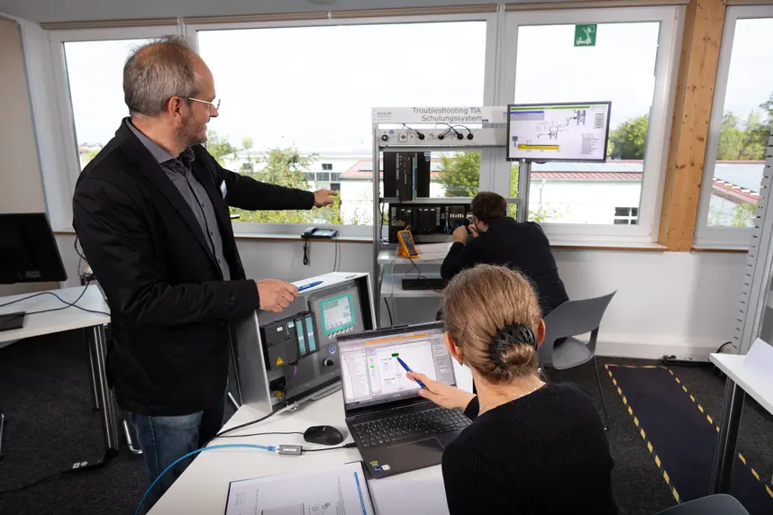 Schulungsleiter erklärt Teilnehmern das Fehlersuche-Simulationsrack auf einem Eichler Tia Portal Seminar